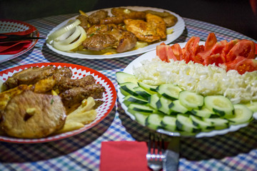 Mixed grilled meat platter Snack, sausages, shank, pork ribs, cutlets, and steaks on the grill Assorted delicious grilled meat with vegetable Mix of various types of barbecue meat decorated with salad