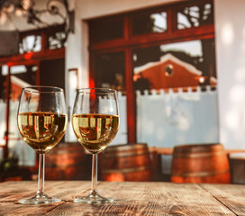 two single glasses of wine wiht free space for your bottle and blurred background. 