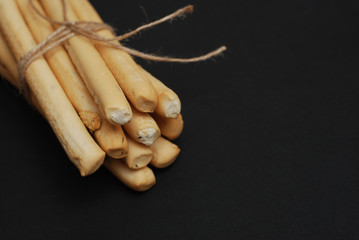 Homemade Grissini Freshly Baked Breadsticks with black background. Isolated.