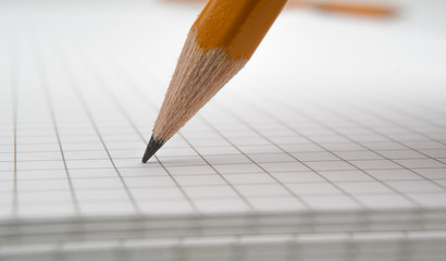 Stylus pencil closeup writes on the notebook.