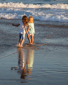 Two little girls on the beach in the late afternoon