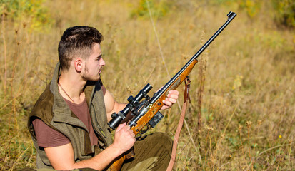 Hunting hobby and leisure. Man charging hunting rifle. Hunting equipment concept. Hunter with rifle looking for animal. Hunter khaki clothes ready to hunt nature background. Hunting shooting trophy