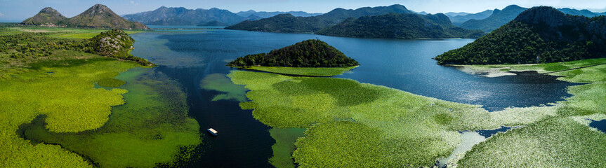 Aerial panoramic view of the beautiful landscape of Lake Skadar in the mountain on a sunny day. Montenegro. The territory of Lake Skadar overgrown with plants.