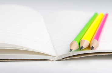 Pencils are on a paper sheet in the line.