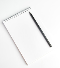 The pencil is on the notebook of the student.