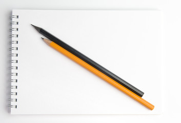 The pencil lying on the notebook. Close up.