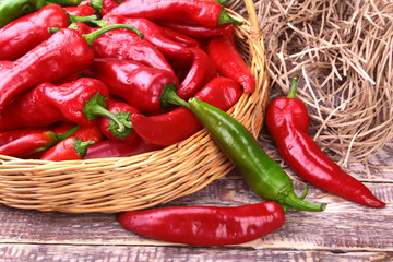 Wicker basket full of fresh red chili peppers.