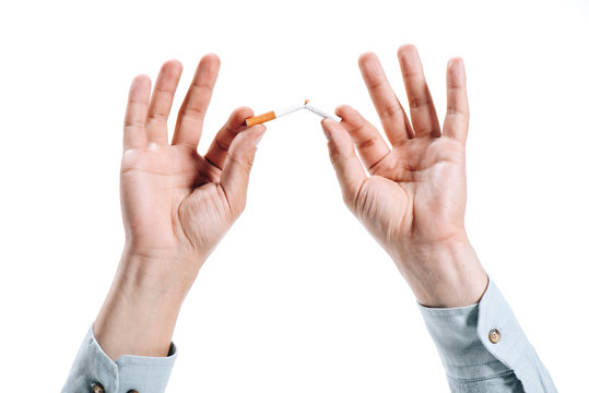 cropped image of man in shirt breaking unhealthy cigarette isolated on white