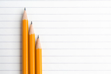 Pencils are on a paper sheet in the line.