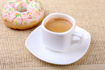 Coffee break with fresh donuts over textile background.