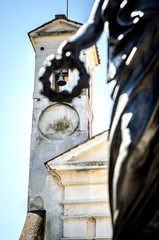 View of the bell tower of the city theater through a wreath of a statue standing in front of the theater. Ariccia, Italy.

