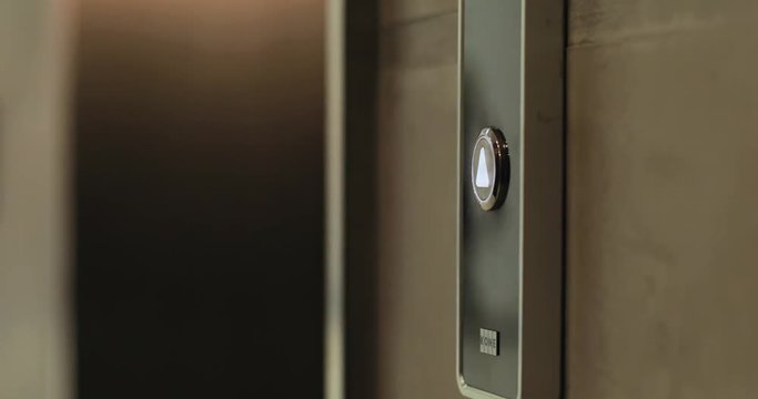 Close up hand young man presses a button of lift to go up by a finger elevator business technology lift push building interior down choice control office open door