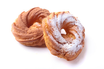 Chocolate and powdered sugar cream puff rings, choux pastry. Isolated on white background.