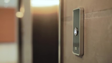 Close up hand young woman presses a button of lift to go up by a finger elevator business technology lift push building interior down choice control office open door