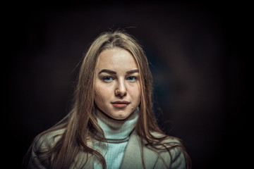 Portrait of young woman in the subway waiting for the train. Looking in the camera. Dark edit