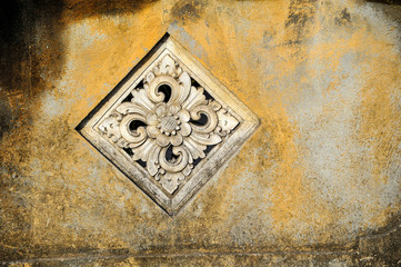 wall with decorative floral stone carving in Ubud, Indonesia