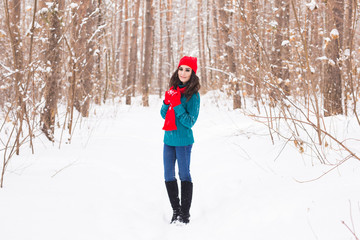 Fototapeta na wymiar Happy young woman walking in winter time. Pretty girl in snowy nature