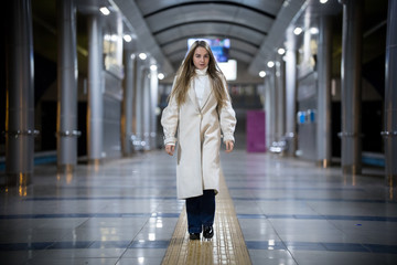 Young woman walking in the subway waiting for the train.