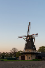 Fototapeta na wymiar Landscape with traditional Dutch grain wind mill and blue sky on sunset, copy space