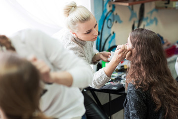 Obraz na płótnie Canvas professional makeup artist doing makeup for client's salon