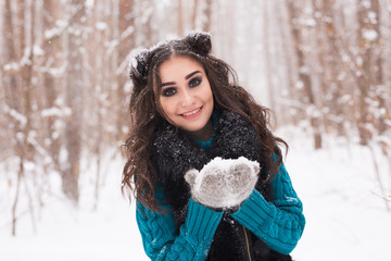 Christmas, holidays and season concept - Young beautiful smiling woman holding snow in hands in winter outdoors