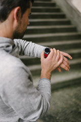Modern sport and running technology concept.  Urban runner using sporty smart watch for training.