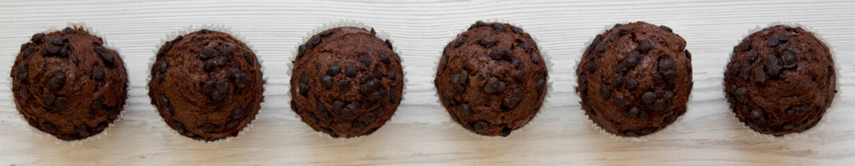 Tasty chocolate muffins on white wooden background, overhead view. Flat lay, from above. Close-up.