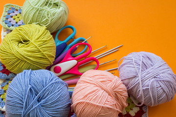 Colorful balls of yarn on an orange background. Colorful background. Copy space. Materials for knitting. The concept of earning needlework.