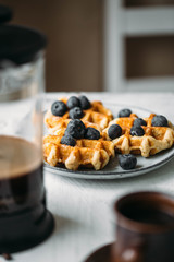 Belgian waffles with berries and coffee in a french press. Good morning concept