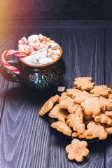 Christmas biscuit cookies next to a mug full of marshmallows