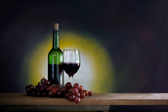 Grape and wine in glass and bottle on the plank in dim light room