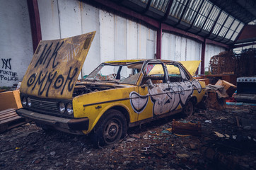Automobile distrutta abbandonata in una fabbrica desolata