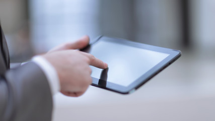 close up. businessman pressing his finger on the screen of the digital tablet