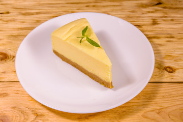White plate with cheesecake New York on wooden table
