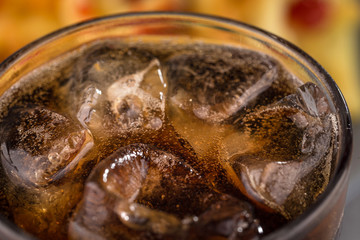 fizzy drink with ice in a glass on the abstract background