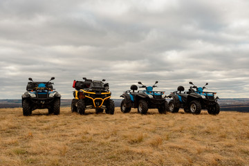 Bright ATVs in the mud are in the field cloudy day, extreme