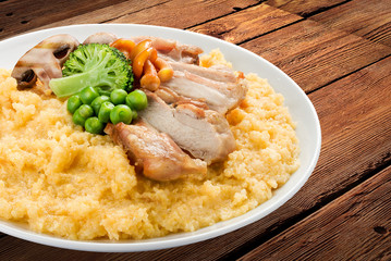 Wheat porridge with pork and vegetables. On a wooden background