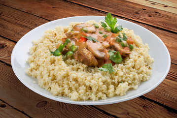 Millet porridge with mushrooms. On a wooden background