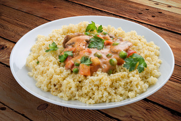 Millet porridge with mushrooms. On a wooden background