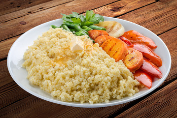 Millet porridge with grilled vegetables. On a wooden background