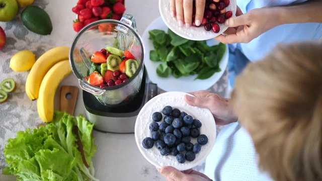 Women Preparing Healthy Green Smoothie With Berries