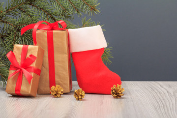 Gift boxes, Santa's boot and fir tree branch on gray background