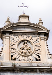 Detail of a church front that represent Saint Mary and the Baby with some little angels in Naples, Italy