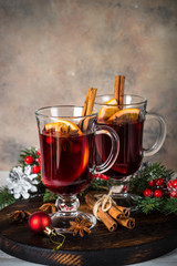 Mulled wine in glass mug with fruit and spices.