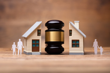 Gavel Between Split Family Figures And House Model