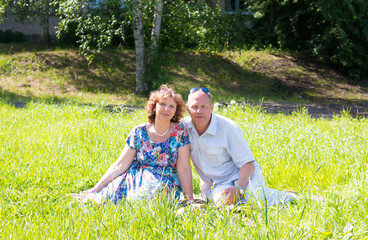 Fototapeta premium man and woman sit on the grass