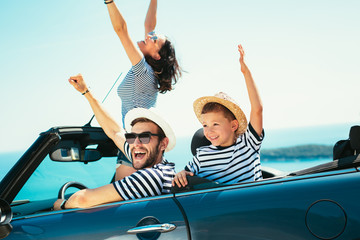 Happy family travel by car to the sea. People having fun in cabriolet. Summer vacation concept