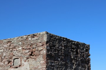 Top of stone tower against blue sky