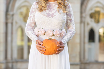 Bride holding pumpkin in her hands