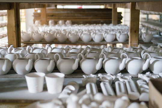 Porcelain factory production of mugs and plates in shelf stacks